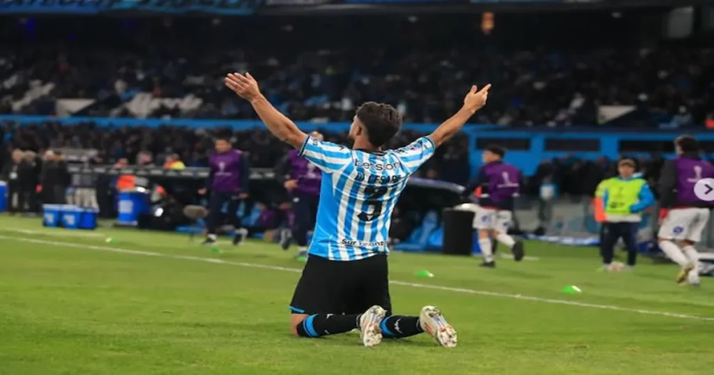 Futbolista de Racing arrodillado en el campo de juego