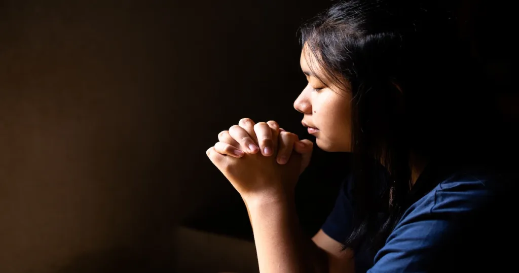 girl praying with her eyes closed