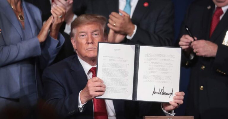 Trump mostrando un decreto firmado por el