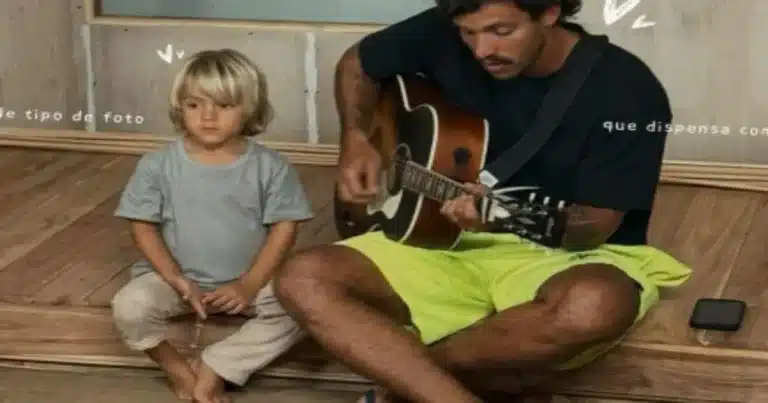 Foto de niño cristiano junto a su padre, quien toca guitarra